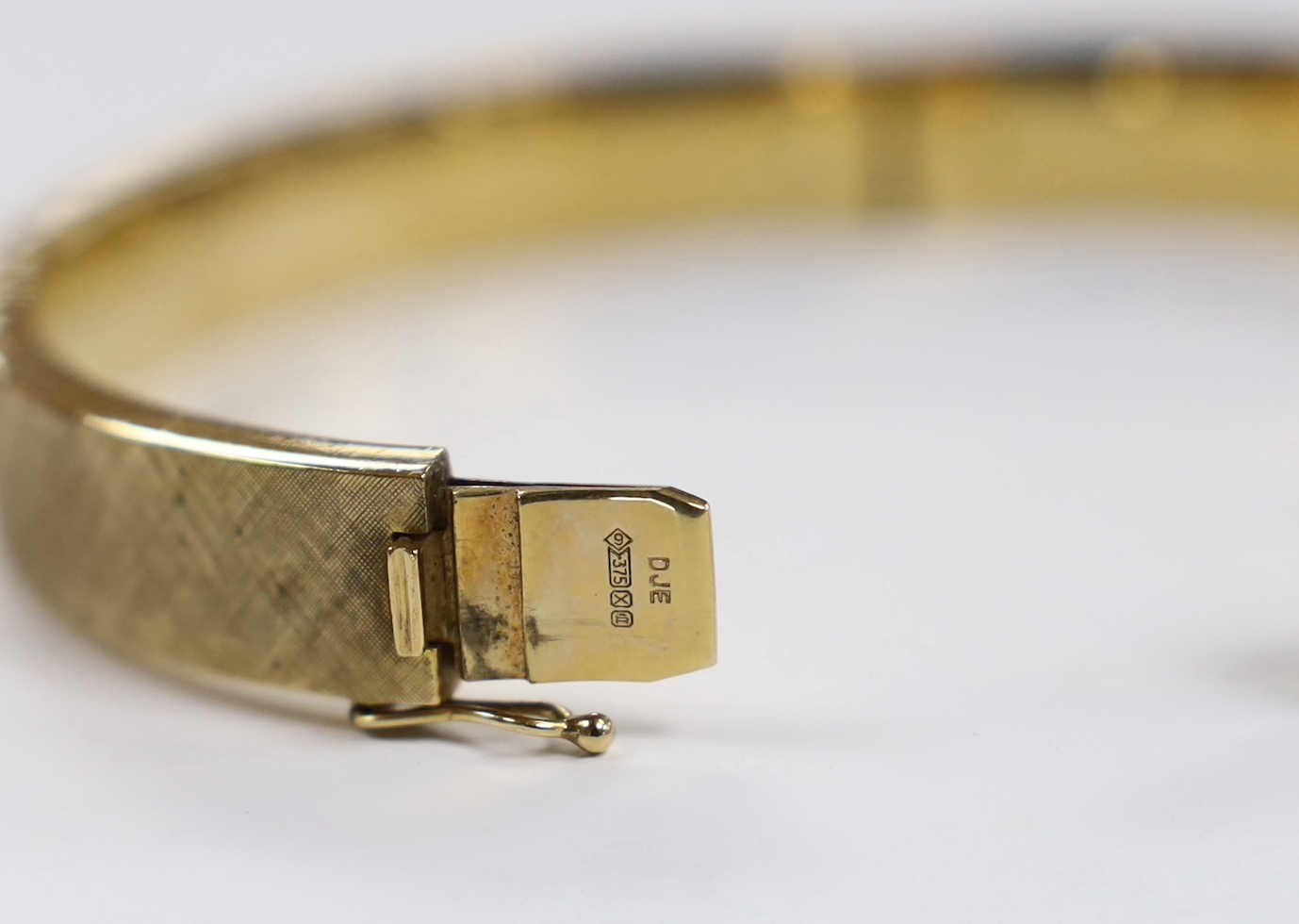 A brushed 9ct gold hinged bangle, interior diameter 63mm, 28.5 grams.